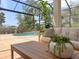 Cozy screened patio offers outdoor seating, a coffee table, and a serene view of the pool and lush greenery at 12311 Newcastle Pl, Lakewood Ranch, FL 34202