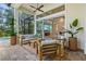 Covered patio with contemporary furniture, fireplace and TV, with views of lush backyard and pool at 12311 Newcastle Pl, Lakewood Ranch, FL 34202
