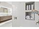 Elegant shower features built-in shelves for toiletries; illuminated mirror and double vanity in background at 12311 Newcastle Pl, Lakewood Ranch, FL 34202
