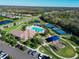 Aerial view of community pool, tennis courts, and playground in a lush, landscaped setting at 12811 Penguin Dr, Bradenton, FL 34212