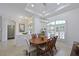 Bright dining area showcasing a wood table with seating for six, and large windows for natural light at 12811 Penguin Dr, Bradenton, FL 34212