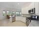 Well-lit kitchen with white cabinets, stainless steel appliances, and a breakfast nook with views at 12811 Penguin Dr, Bradenton, FL 34212
