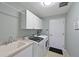 A well-lit laundry room with white cabinets, modern washer and dryer, and a convenient utility sink at 12811 Penguin Dr, Bradenton, FL 34212
