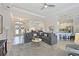 Bright living room with a large sectional sofa, neutral tones, and an open layout to dining and kitchen at 12811 Penguin Dr, Bradenton, FL 34212