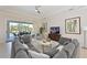 Inviting living room with a large sectional sofa, neutral tones, and views of the outdoor pool area at 12811 Penguin Dr, Bradenton, FL 34212