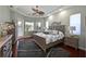 Comfortable bedroom featuring tray ceilings, hardwood floors and bright windows at 12811 Penguin Dr, Bradenton, FL 34212