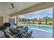 Outdoor dining on this screened-in patio with ceiling fan, overlooking the beautiful pool and lush landscape at 12811 Penguin Dr, Bradenton, FL 34212