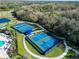 Aerial view of community tennis and pickleball courts surrounded by green space at 12811 Penguin Dr, Bradenton, FL 34212