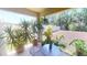 Covered back patio featuring potted plants and seating, overlooking a lush backyard at 141 Tierra Verde Way, Bradenton, FL 34212