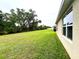 Spacious backyard with a large tree and lawn, located off the rear of the home at 141 Tierra Verde Way, Bradenton, FL 34212