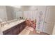 Bathroom featuring double sinks, white cabinets, and a shower with floral curtain at 141 Tierra Verde Way, Bradenton, FL 34212