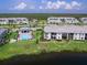 Aerial view showcasing lakefront community with a swimming pool and lush landscaping at 14214 Heritage Landing Blvd # 817, Punta Gorda, FL 33955