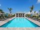 Stunning rectangular community pool with sun loungers and clear blue water, surrounded by palm trees at 14214 Heritage Landing Blvd # 817, Punta Gorda, FL 33955