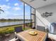 Enclosed lanai with beautiful water view, table, grill, and white textured wall at 14214 Heritage Landing Blvd # 817, Punta Gorda, FL 33955