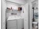 Convenient laundry closet with washer, dryer, and shelving next to a well-appointed bathroom at 14214 Heritage Landing Blvd # 817, Punta Gorda, FL 33955