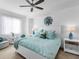 Calm bedroom with white furniture, ceiling fan, and a large window for natural light at 14214 Heritage Landing Blvd # 817, Punta Gorda, FL 33955
