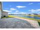 Paver patio overlooking a serene pond with neighborhood views and beautiful sky at 14444 59Th E Cir, Bradenton, FL 34211
