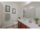 Bathroom with dark wood vanity, toilet, framed pictures on the wall, and a shower with a striped curtain at 14444 59Th E Cir, Bradenton, FL 34211