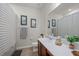 Bathroom with a dark wood vanity, toilet, mirror, and framed pictures on the wall at 14444 59Th E Cir, Bradenton, FL 34211