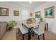 Dining area with a marble table, upholstered chairs, bench seating and decorative artwork on the walls at 14444 59Th E Cir, Bradenton, FL 34211
