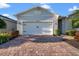 Close-up of the garage with brick paver driveway and lush landscaping in the front yard at 14444 59Th E Cir, Bradenton, FL 34211