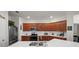 Well-lit kitchen with stainless steel appliances, wood cabinets, and a center island with a sink at 14444 59Th E Cir, Bradenton, FL 34211
