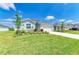 Well-maintained home with a lush lawn, landscaped garden, and a concrete driveway leading to an attached garage at 16109 6Th E Ave, Bradenton, FL 34212