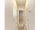 A hallway with neutral walls and tile flooring leads to various rooms with doors on either side at 16109 6Th E Ave, Bradenton, FL 34212