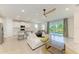 Open concept living area with kitchen, sofa, and sliding doors leading to a screened lanai with view to the outdoors at 16109 6Th E Ave, Bradenton, FL 34212
