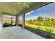 Covered patio showcasing the serene backyard with a fence and lush greenery at 16109 6Th E Ave, Bradenton, FL 34212