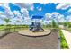 Community playground with colorful play structure surrounded by mulch and lush landscaping at 16109 6Th E Ave, Bradenton, FL 34212