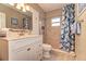 Updated bathroom features vanity, toilet and tiled shower with curtain; neutral tile and decor at 1731 Redwood St, Sarasota, FL 34231