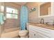 Updated bathroom with a shower-tub combination, blue shower curtain, and stylish vanity with granite countertop at 1731 Redwood St, Sarasota, FL 34231