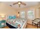 Charming bedroom with light yellow walls, wood floors, ceiling fan and two windows, plus coastal decor at 1731 Redwood St, Sarasota, FL 34231