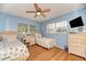 Bright bedroom featuring twin beds, wood flooring, and a desk area for studying or creative activities at 1731 Redwood St, Sarasota, FL 34231