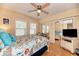 Charming bedroom with light yellow walls, wood floors, ceiling fan and two windows, plus coastal decor at 1731 Redwood St, Sarasota, FL 34231