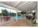 Relaxing covered patio with a variety of seating options, overlooking the refreshing pool and lush backyard at 1731 Redwood St, Sarasota, FL 34231