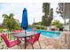 Inviting pool area with a table, chairs, and an umbrella, perfect for outdoor dining and relaxation at 1731 Redwood St, Sarasota, FL 34231