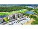 Aerial view of the community building with golf course, a lake, and covered parking at 17510 Gawthrop Dr # 206, Bradenton, FL 34211