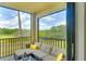 View from the balcony of a neutral colored cushioned couch, overlooking the green golf course at 17510 Gawthrop Dr # 206, Bradenton, FL 34211