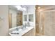 Bathroom with a marble vanity, a large mirror, and a glass-enclosed shower with tiled walls at 17510 Gawthrop Dr # 206, Bradenton, FL 34211