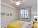 Bedroom features a white bed frame with yellow accents, complemented by beach-themed wall art at 17510 Gawthrop Dr # 206, Bradenton, FL 34211