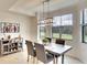 Dining area with a gray table and chairs, complemented by a modern chandelier and large windows at 17510 Gawthrop Dr # 206, Bradenton, FL 34211