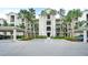 Beautiful condo exterior featuring palm trees, covered parking, and meticulously maintained landscaping at 17510 Gawthrop Dr # 206, Bradenton, FL 34211