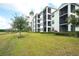 Exterior view of the condo complex featuring multiple screened balconies and lush green grass at 17510 Gawthrop Dr # 206, Bradenton, FL 34211