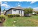 Beautifully landscaped backyard with lush green lawn, tropical tree, and patio at 17885 Cherished Loop, Bradenton, FL 34211