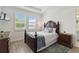 This primary bedroom is bright with two windows and features a dark wood bed frame and matching dressers at 17885 Cherished Loop, Bradenton, FL 34211