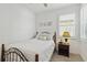 This light-filled bedroom has a metal bed frame, neutral walls, and a window at 17885 Cherished Loop, Bradenton, FL 34211
