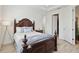 This primary bedroom has a dark wood bed frame, two white doors, and light hardwood floors at 17885 Cherished Loop, Bradenton, FL 34211