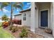 Inviting entryway with a blue front door, column, and lush landscaping at 17885 Cherished Loop, Bradenton, FL 34211